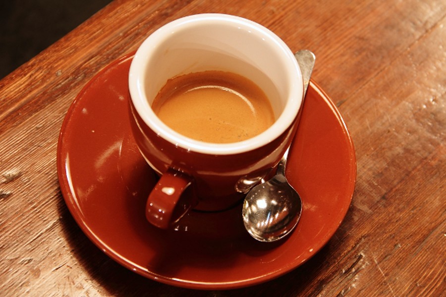 Illustrative real photograph of a cup of coffee on a wooden surface, photographed by Rachel Michetti
